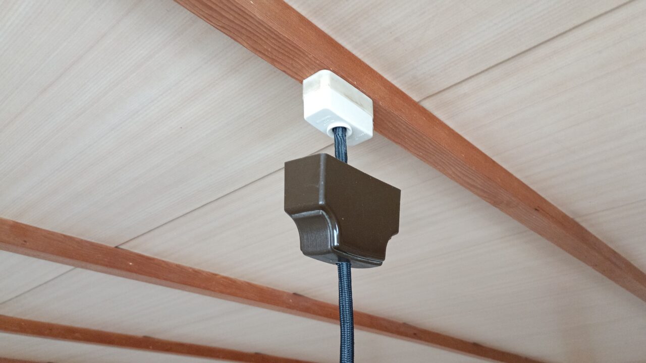 シーリングカバーを手で下にずらしているところ