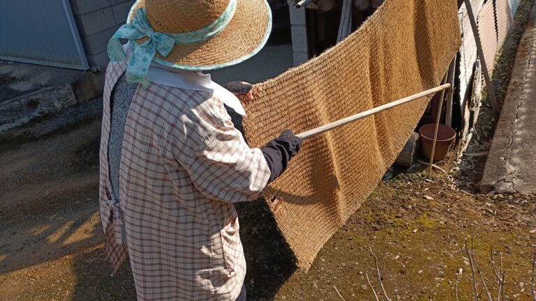 1人でムシロ叩きをする母親