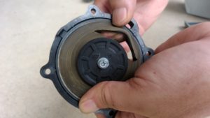 浄化槽ブロアのダイヤフラムの破れている箇所を指し示しているところ