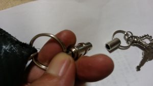 脱着式キーリングを指で外しているところ
