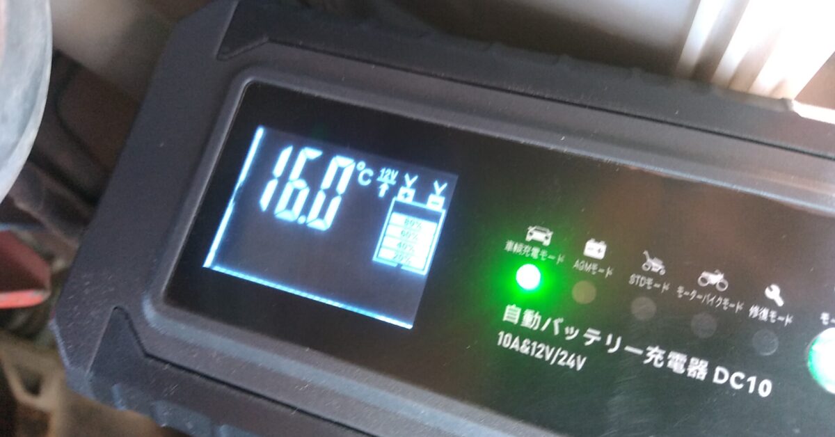 トラクターのバッテリーにバッテリー充電器を接続した写真