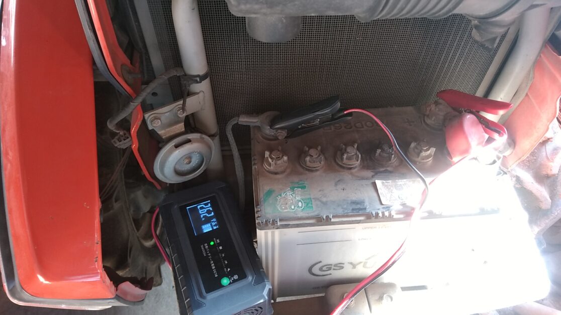 トラクターのバッテリーにワニ口クリップを使ってバッテリー充電器を接続したところ